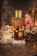 Lattafa Ameer Al Oudh Intense Oud perfume bottle with sugar and vanilla scent notes in the background, warm sweet woody fragrance for men